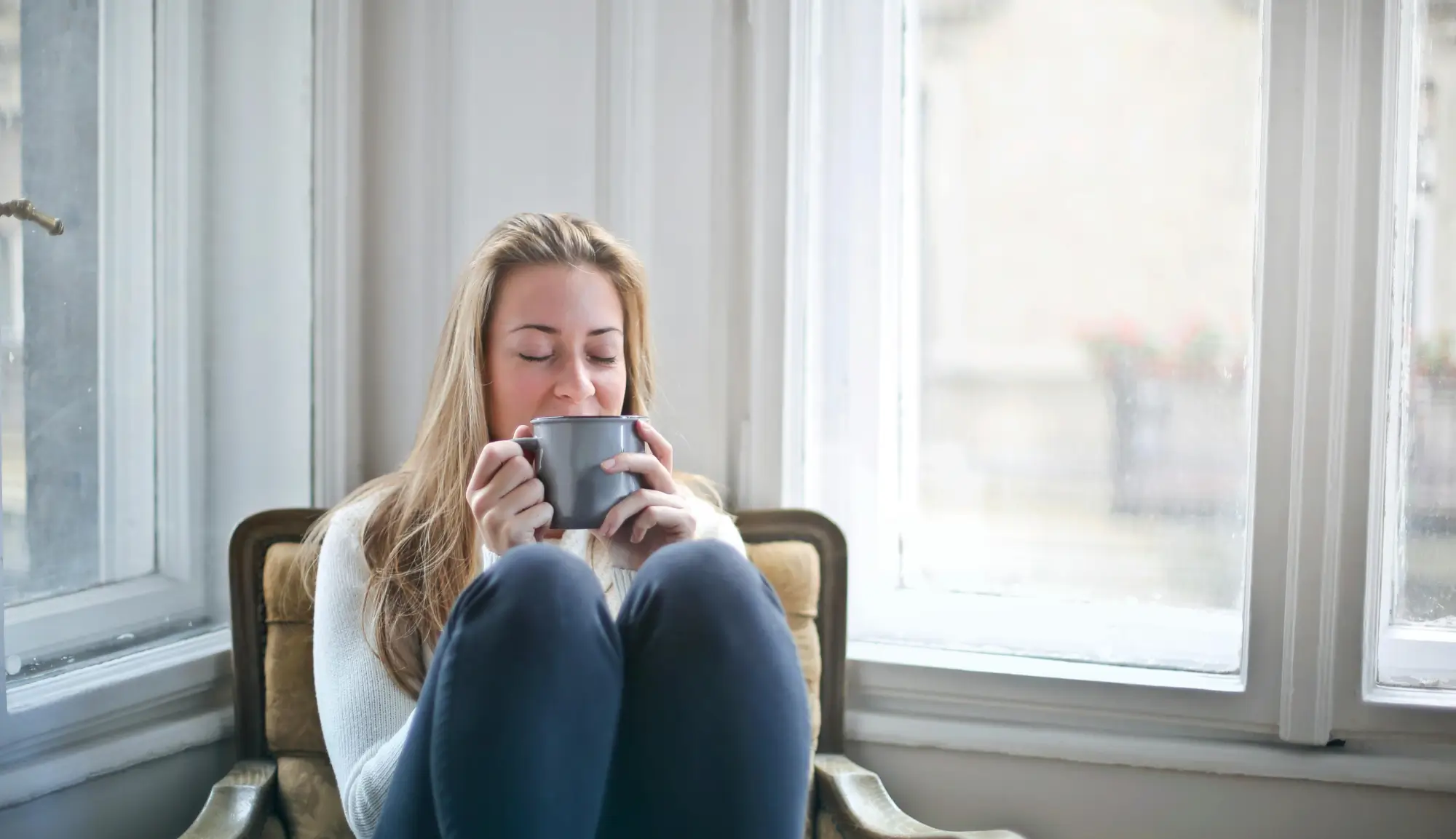 Smiling woman in a chair holding a cup 