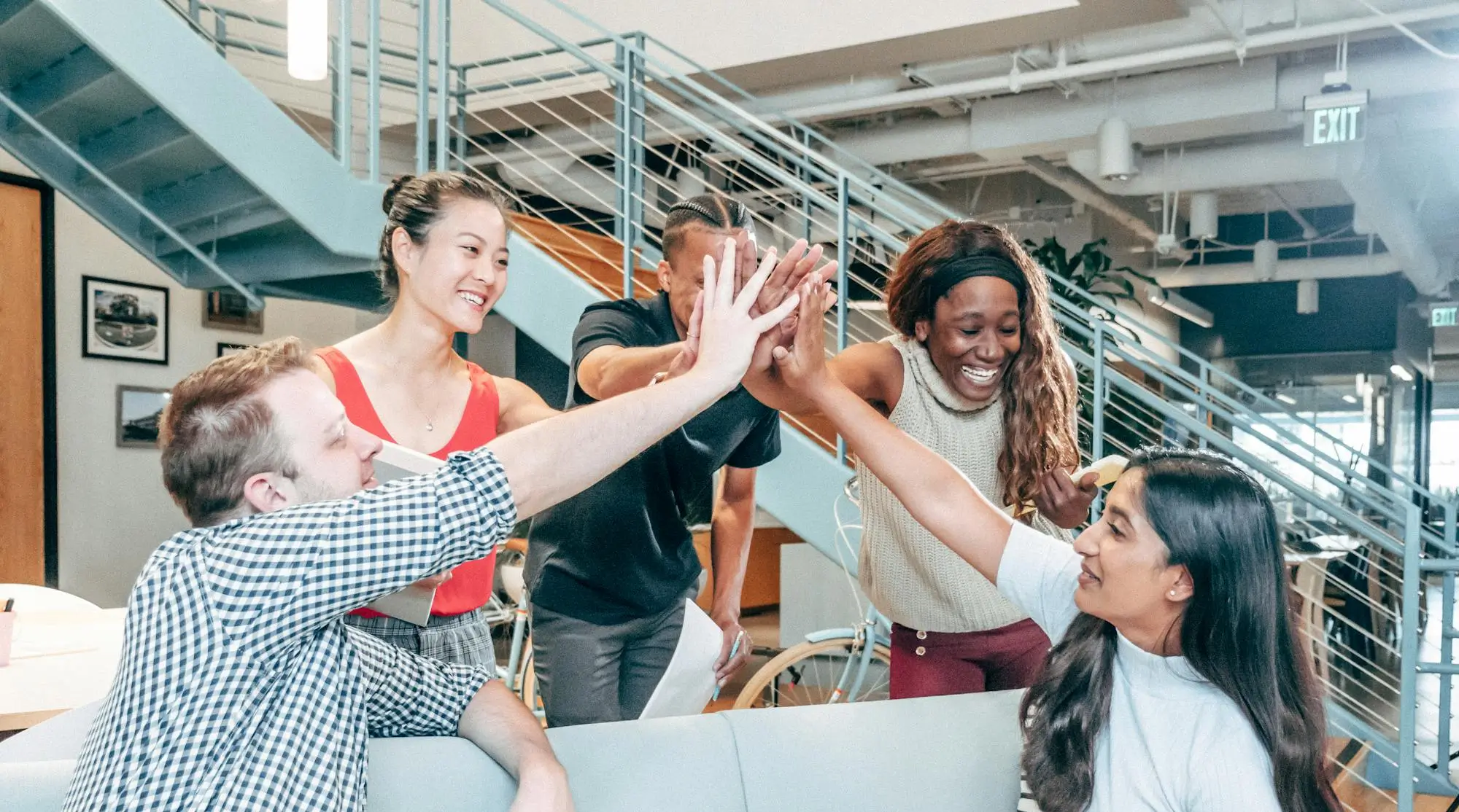 Team high-fiving, showcasing positive work environment