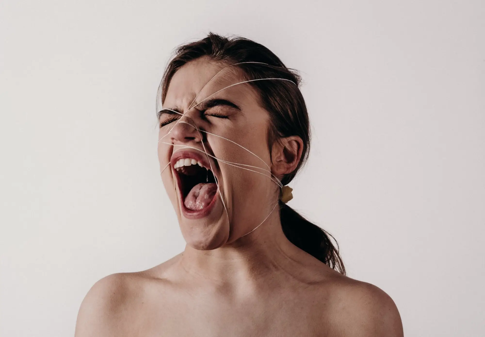 A woman with a facial expression that shows her shouting and experiencing intense emotions 